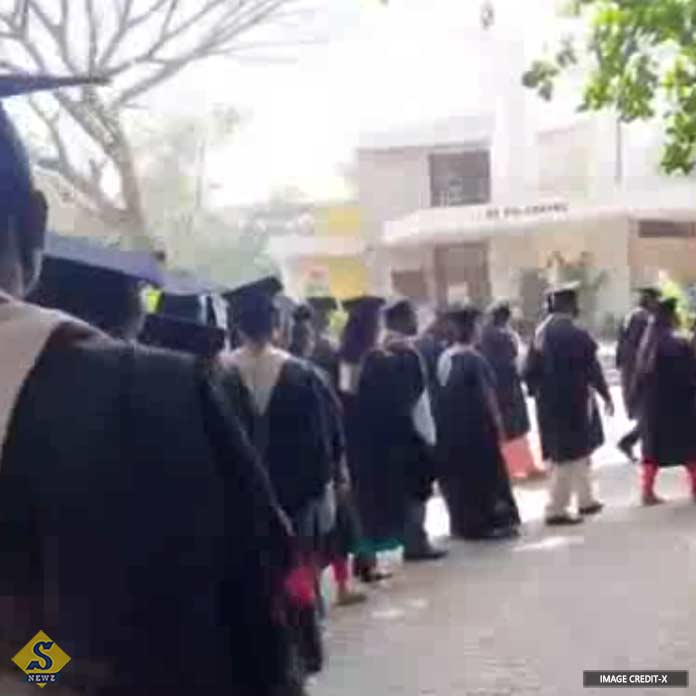 Center against black dress in convocation of doctors