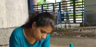 বিকাশ ভবনের সামনের রাস্তায় খাতা দেখছেন শিক্ষিকা