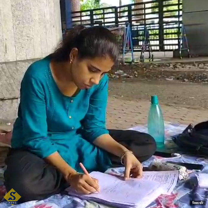 বিকাশ ভবনের সামনের রাস্তায় খাতা দেখছেন শিক্ষিকা 